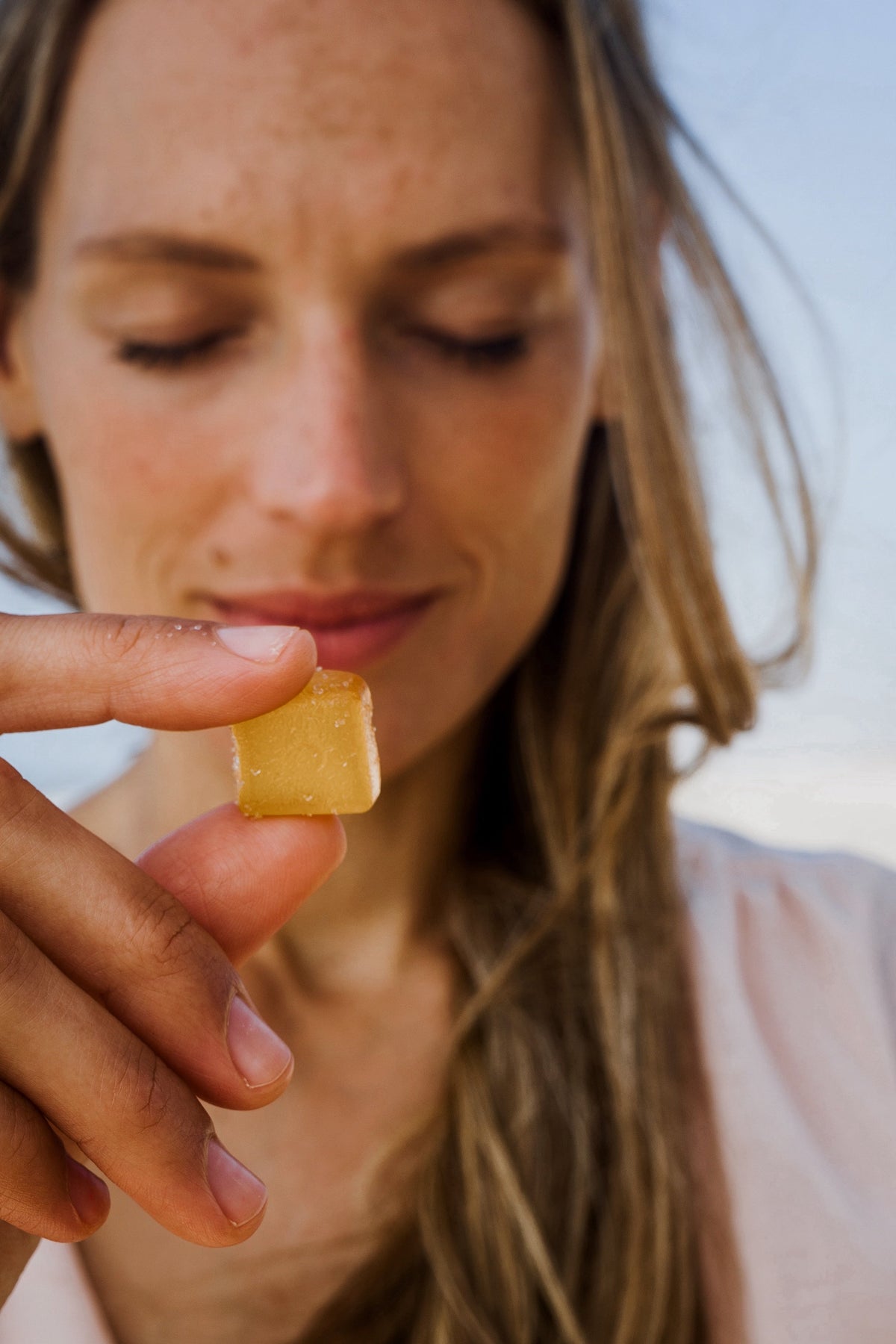 A woman with an energy gummy featuring THCV.