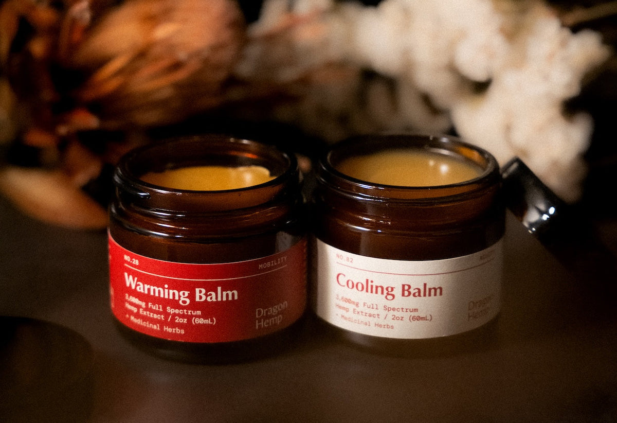 Dragon Hemp Warming Balm and Cooling Balm side by side — pattern-matched topicals descended from the dit da jow martial arts lineage