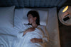 Woman relaxing in bed using Dragon Hemp melatonin-free sleep tincture.